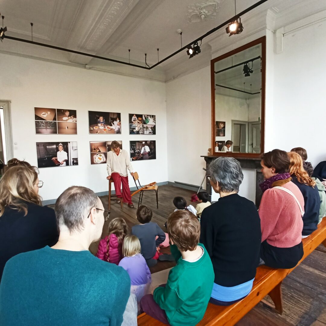 groupe de parents et enfants écoutant l'histoire d'un conteur