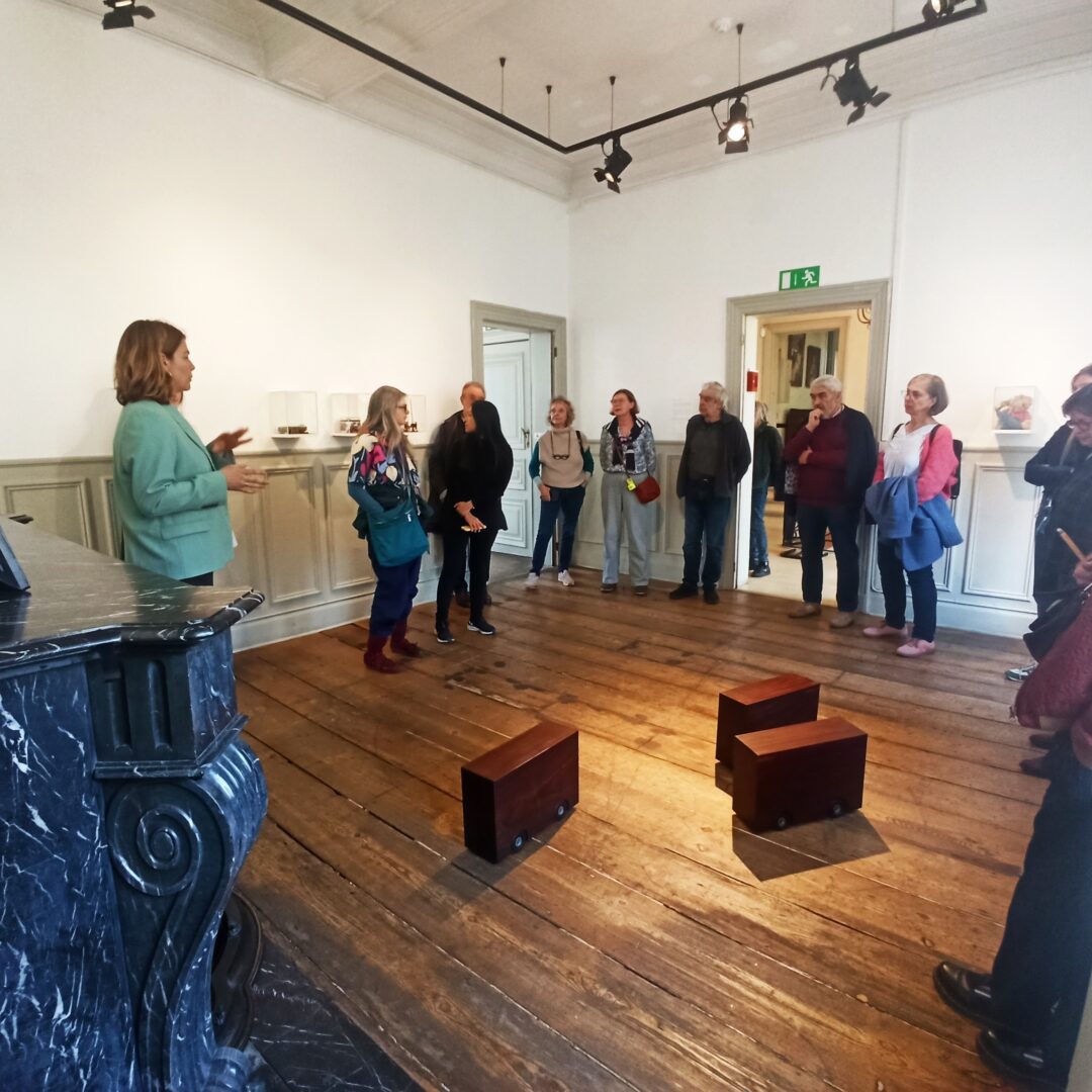 groupe de personne ecoutant un guide leur parlant des oeuvres les entourants dans la pièce